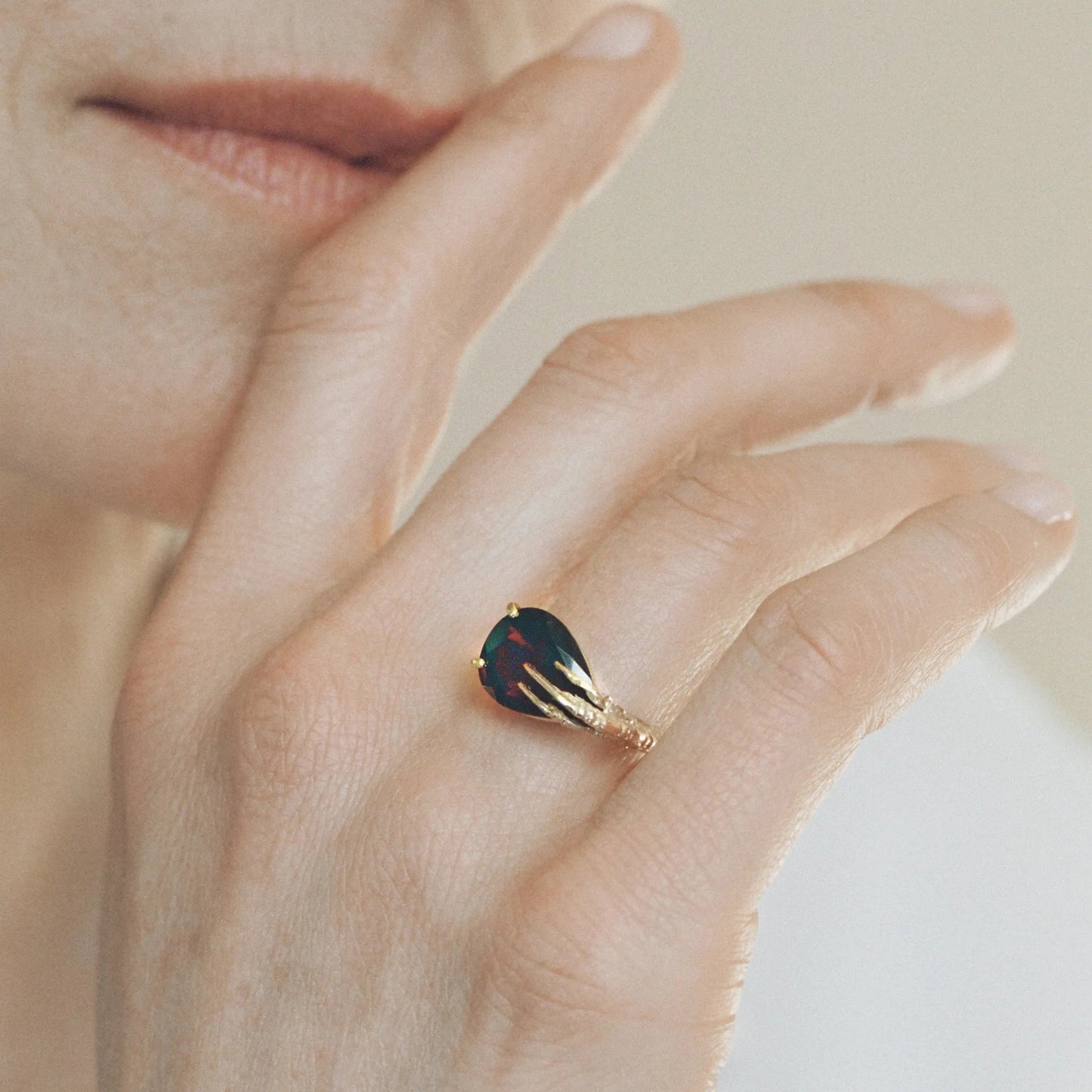 Signature grigri ring clasping a garnet in 18 ct. gold